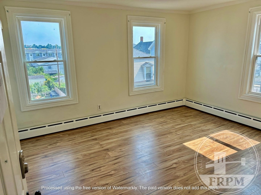 197 Rodman Street, Unit 3C4 Fall River, MA 02721 - Photo 2 of 2 an empty room with wooden floor and windows
