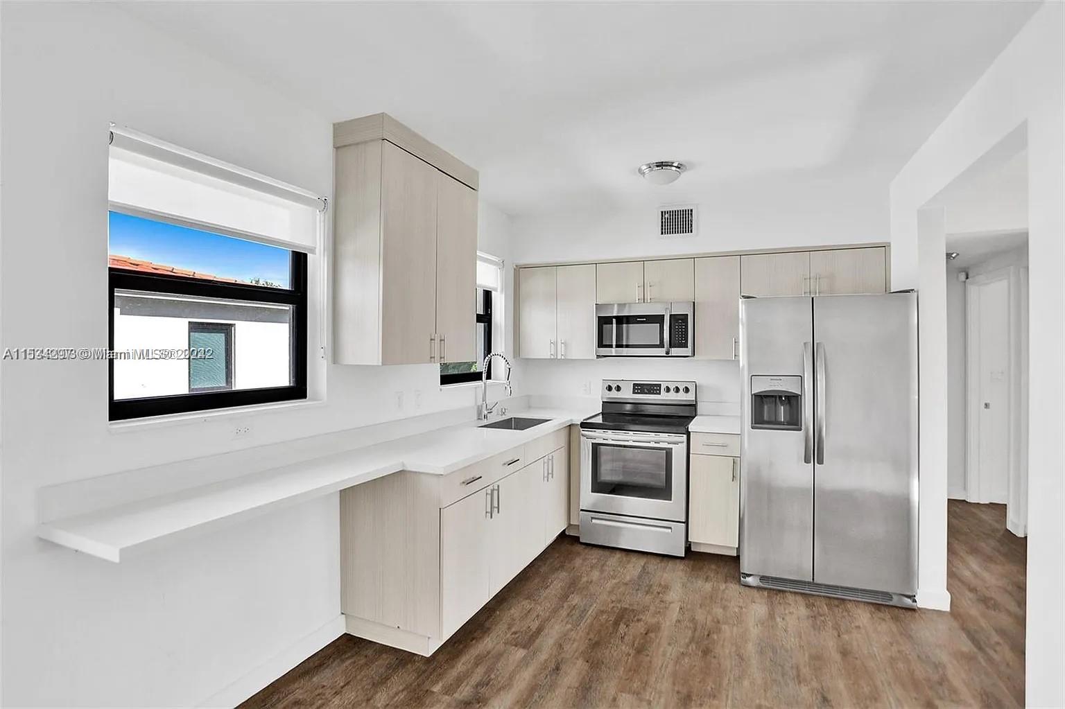 4203 Southwest 15th Street, Unit 2 Miami, FL 33145 - Photo 1 of 13 a kitchen with stainless steel appliances granite countertop a stove a sink and a refrigerator