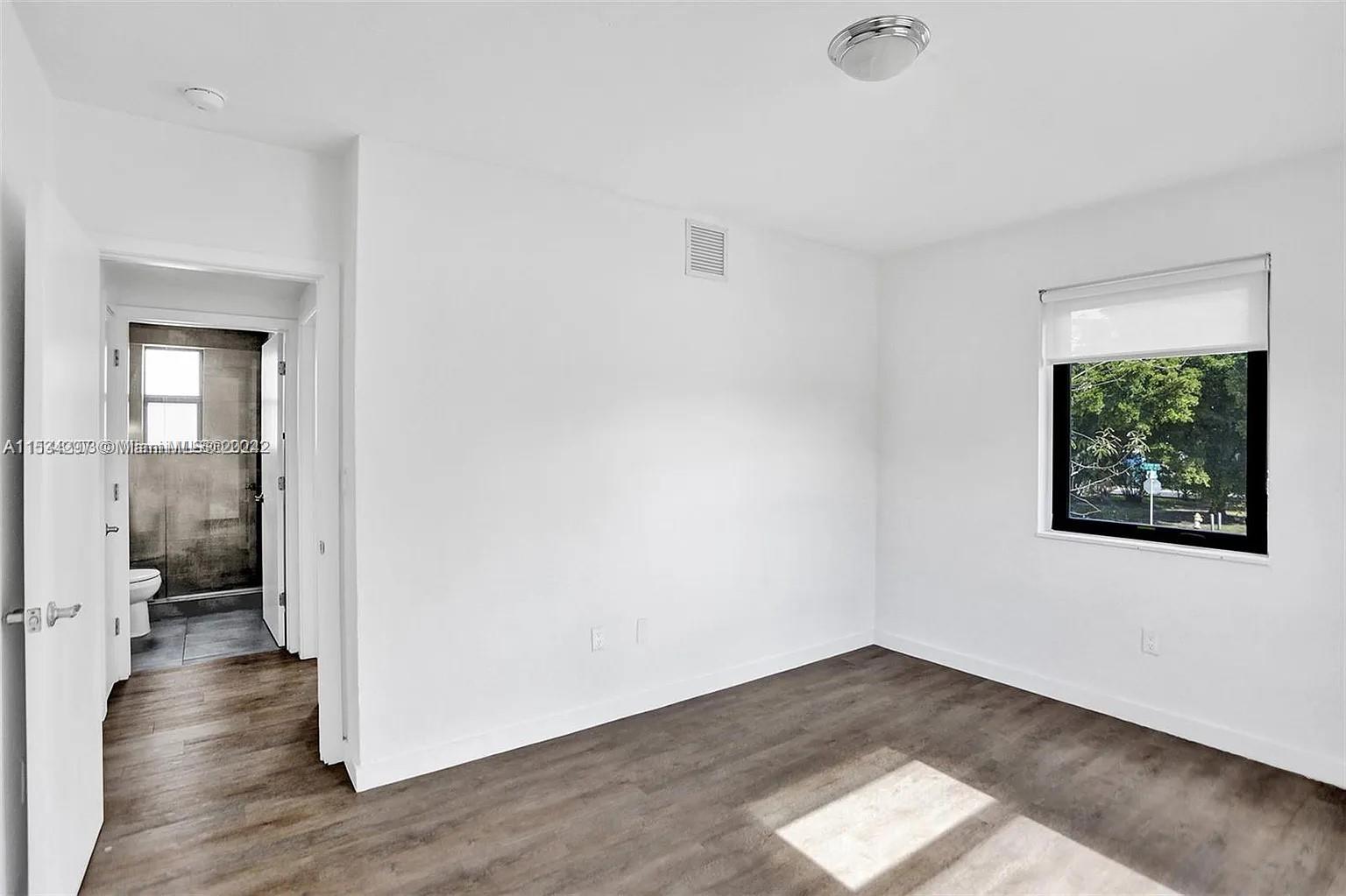 4203 Southwest 15th Street, Unit 2 Miami, FL 33145 - Photo 5 of 13 a view of an empty room with wooden floor and a window