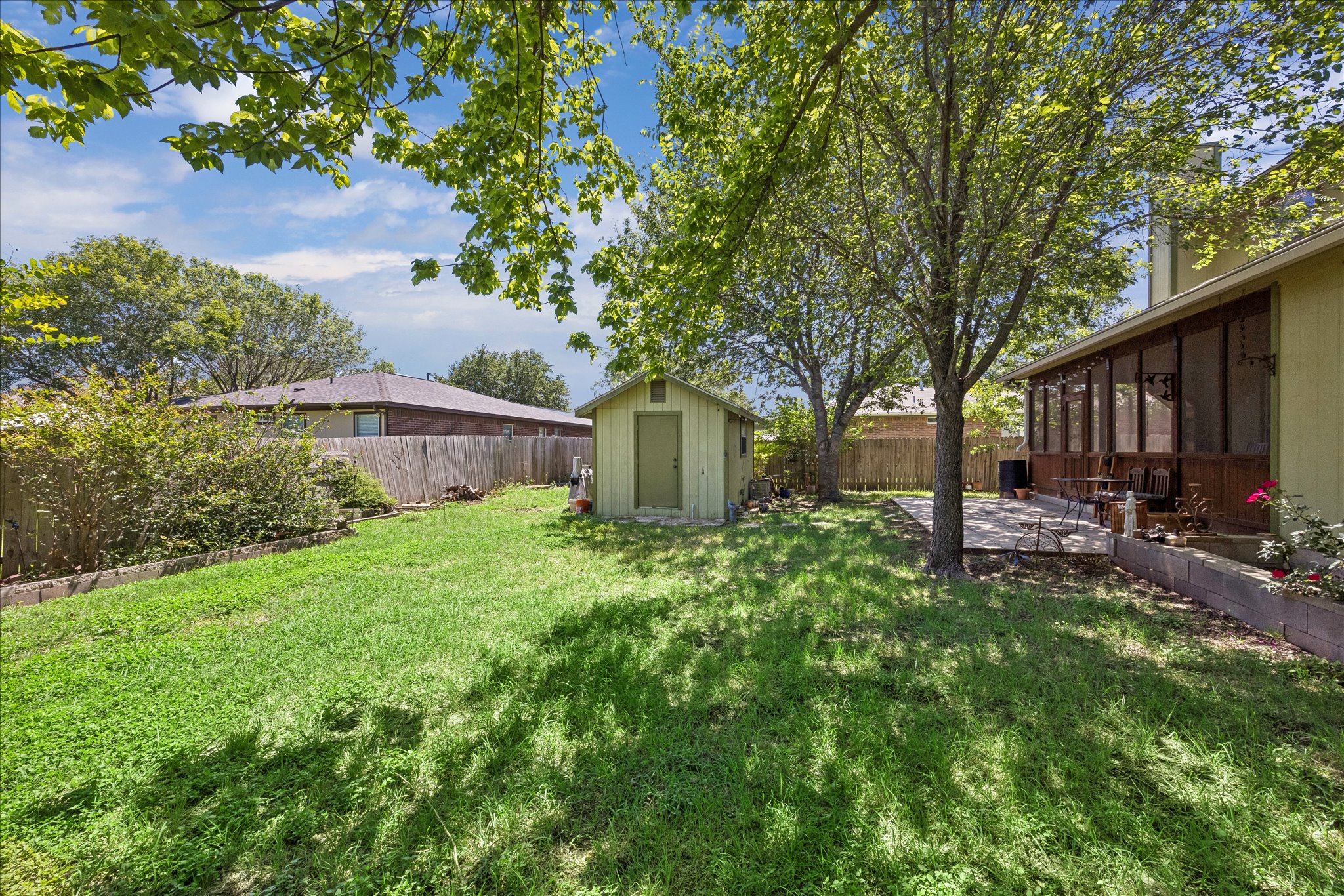 338 Spring Branch Loop Kyle, TX 78640 - Photo 29 of 36 A well-maintained yard offers a private retreat, complete with a storage shed and a charming screened porch.