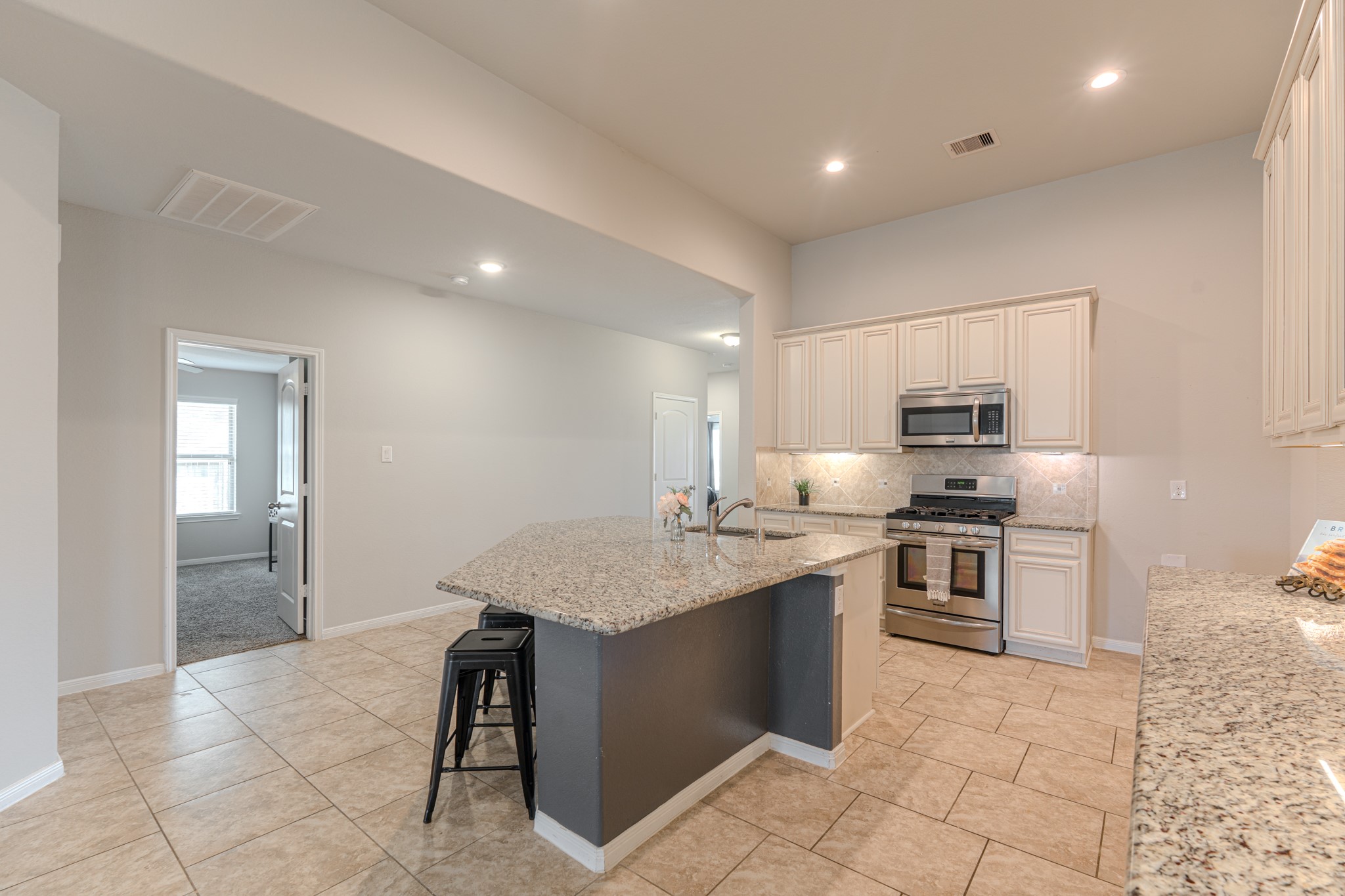 14207 Irvine Rnch Trail Conroe, TX 77384 - Photo 8 of 29 a kitchen with stainless steel appliances granite countertop a stove a sink a refrigerator and a granite counter tops with white cabinets