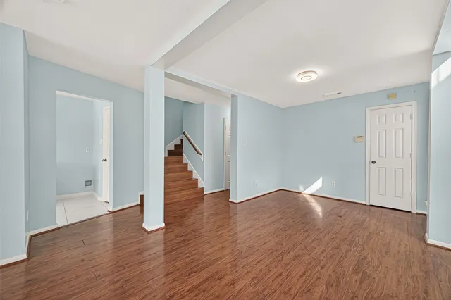 a view of a hallway with wooden floor and staircase