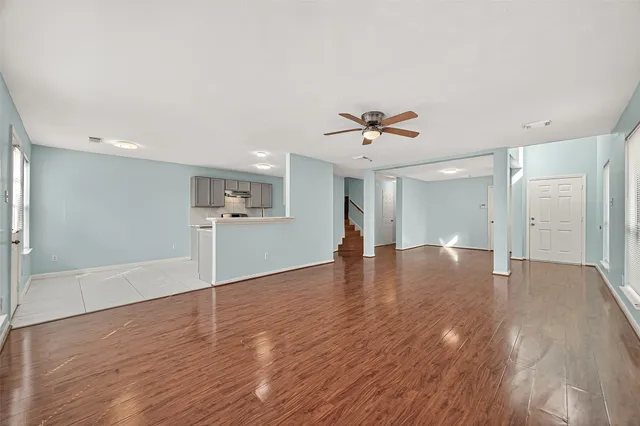 a view of an empty room with a window and wooden floor