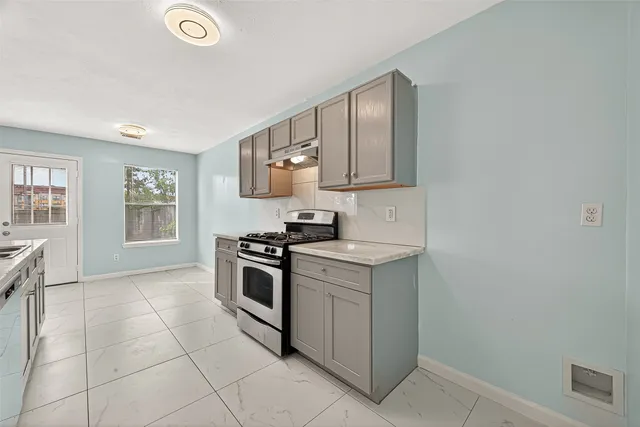 a kitchen with a stove top oven and cabinets