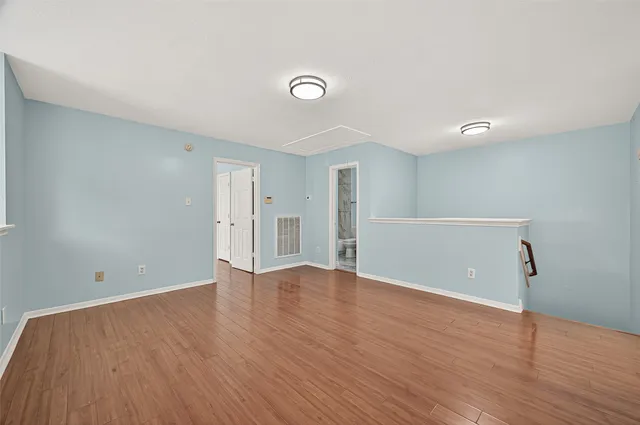 a view of an empty room with wooden floor