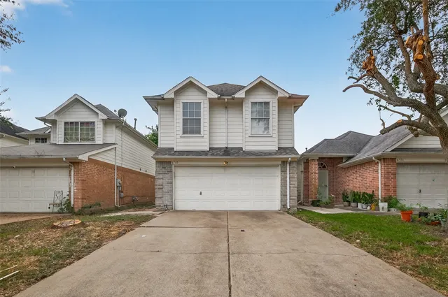 a view of a house with a yard and garage