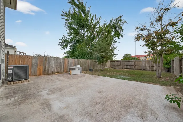 a view of backyard with wooden fence