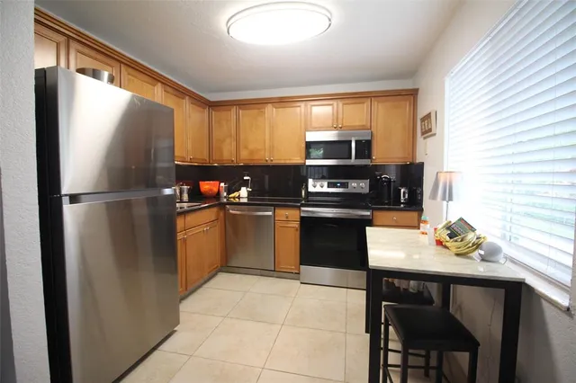 a kitchen with a sink appliances cabinets and furniture