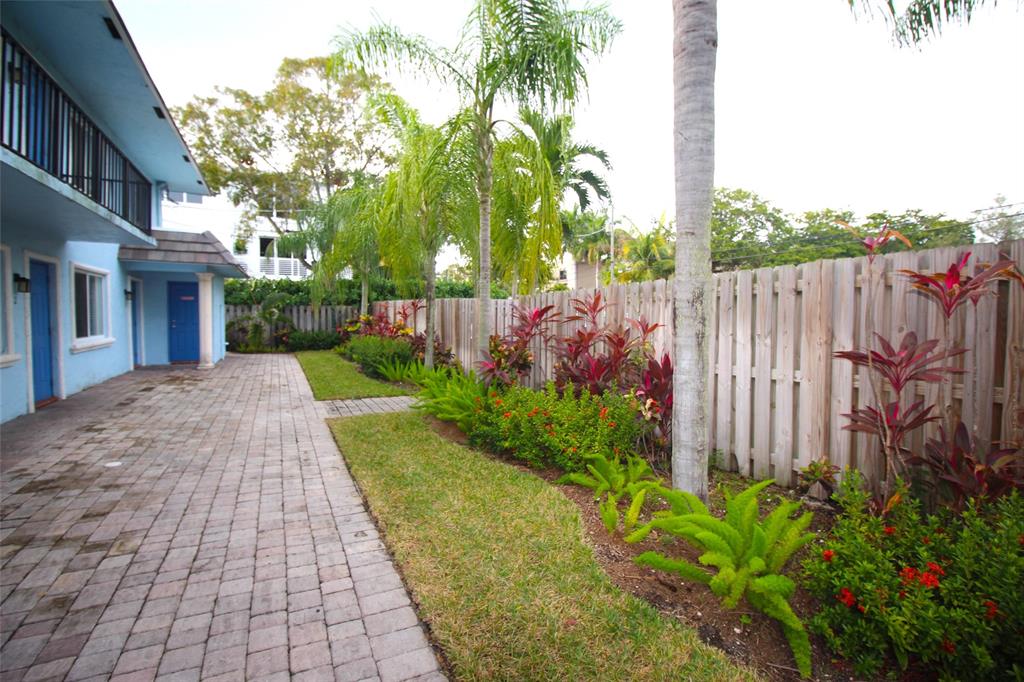 820 Northeast 28th Street, Unit 1 Wilton Manors, FL 33334 - Photo 16 of 17 a view of a backyard with brick wall and potted plants