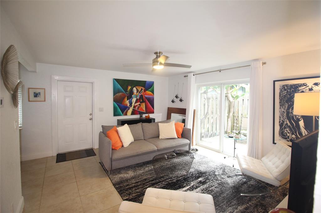 820 Northeast 28th Street, Unit 1 Wilton Manors, FL 33334 - Photo 2 of 17 a living room with furniture and a flat screen tv