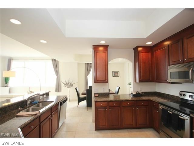 2104 West First Street, Unit 3204 Fort Myers, FL 33901 - Photo 14 of 21 a kitchen with granite countertop a sink cabinets and stainless steel appliances