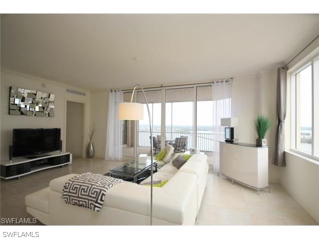 2104 West First Street, Unit 3204 Fort Myers, FL 33901 - Photo 17 of 21 a living room with furniture a flat screen tv and a floor to ceiling window