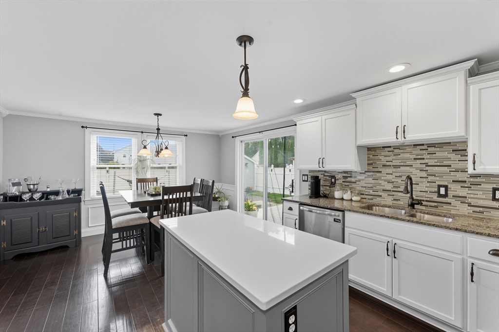 53 Druids Lane West Springfield, MA 01089 - Photo 18 of 42 a kitchen with stainless steel appliances kitchen island granite countertop a stove top oven a sink a dining table and chairs with wooden floor