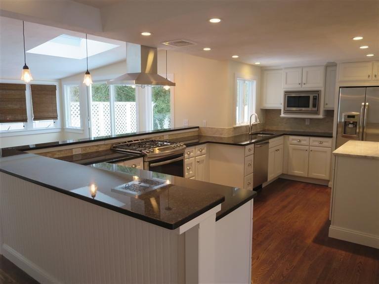 a kitchen with stainless steel appliances granite countertop a sink a stove top oven a counter space and cabinets