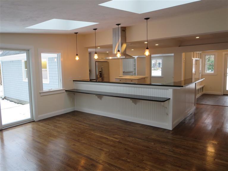 138 South Main Street Centerville, MA 02632 - Photo 8 of 35 a view of a kitchen with kitchen island a sink wooden floor and a large window