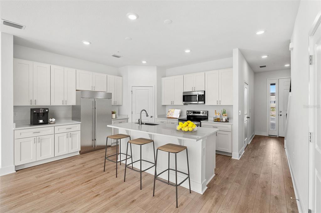 2433 Magnolia Reserve Road Ocoee, FL 34761 - Photo 5 of 14 a kitchen with stainless steel appliances a refrigerator a stove a sink dishwasher and a refrigerator with wooden floor