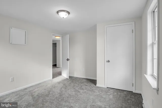 an empty room with windows and closet