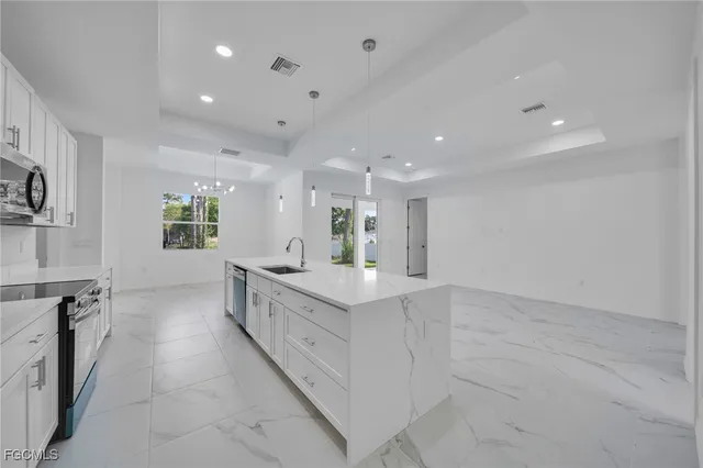 a large white kitchen with a large window