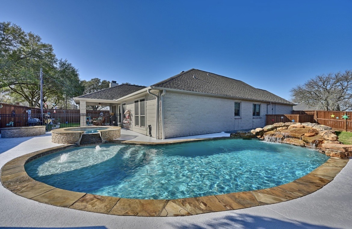 a view of a house with backyard sitting area and swimming pool