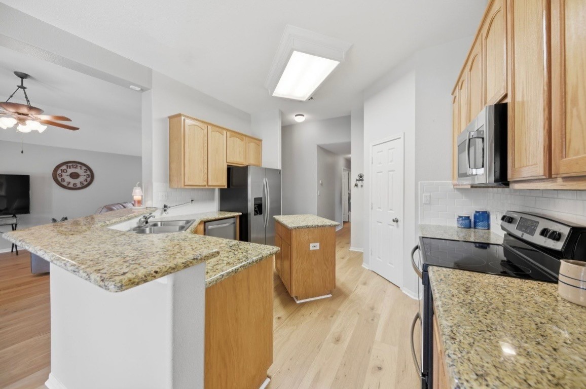 306 Matula Avenue Schulenburg, TX 78956 - Photo 6 of 21 a kitchen with sink refrigerator and microwave