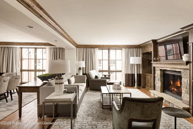 a living room with furniture a fireplace and a large window