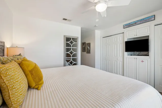 a bedroom with a bed tv and a window