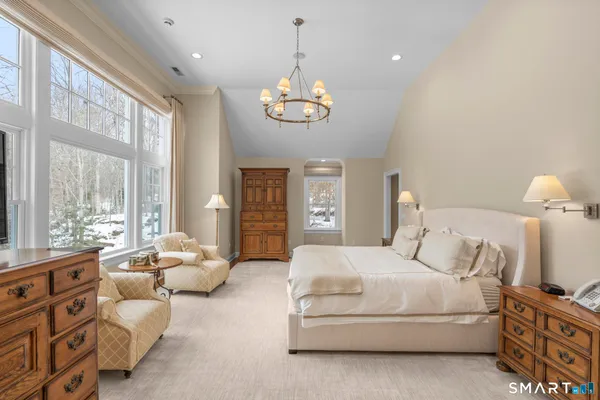 a spacious bedroom with a bed and a chandelier