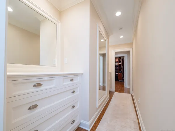 a view of hallway with closet and mirror