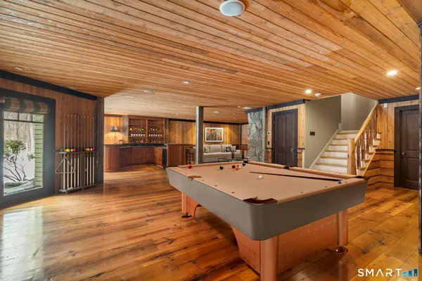 a room with pool table and wooden floor