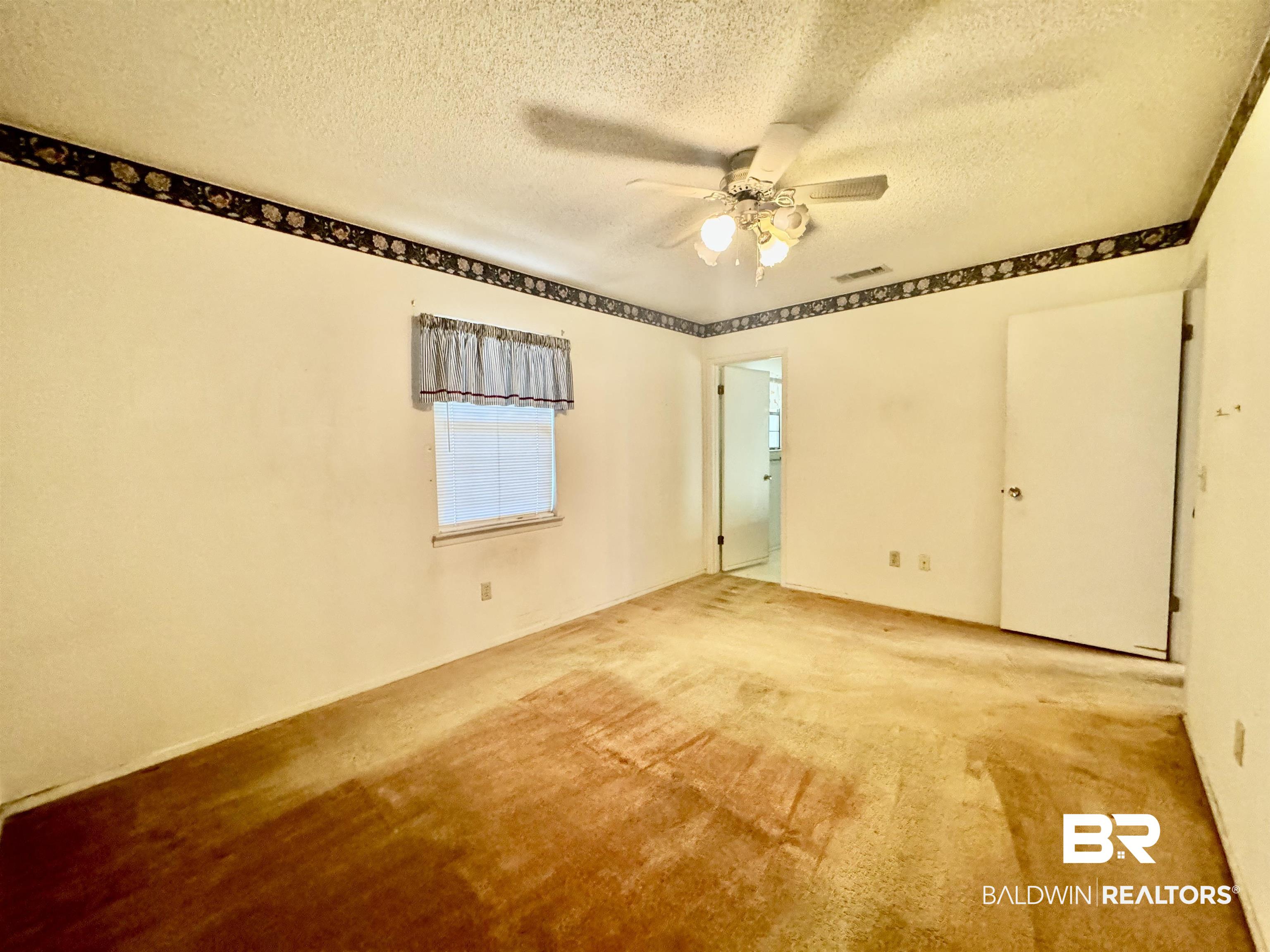 512 Deborah Court Foley, AL 36535 - Photo 22 of 23 Unfurnished room with ceiling fan, light colored carpet, and a textured ceiling