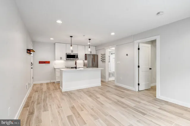 a kitchen with stainless steel appliances a stove microwave and refrigerator