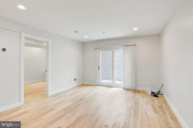 a view of an empty room with wooden floor