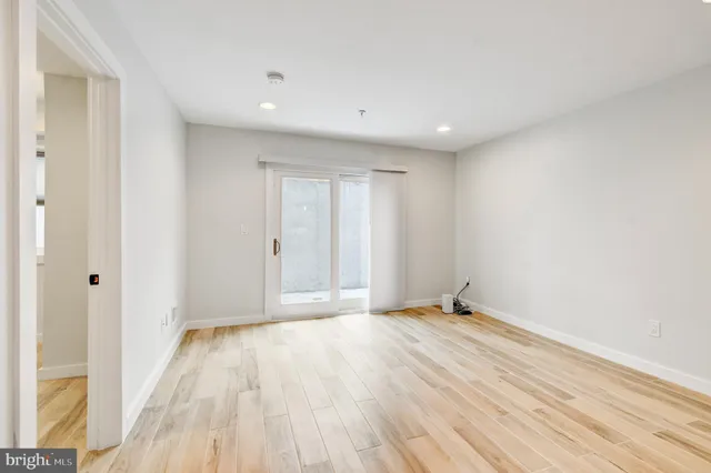a kitchen that has a lot of white cabinets and wooden floor