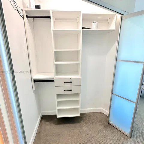 a view of walk in closet with empty racks