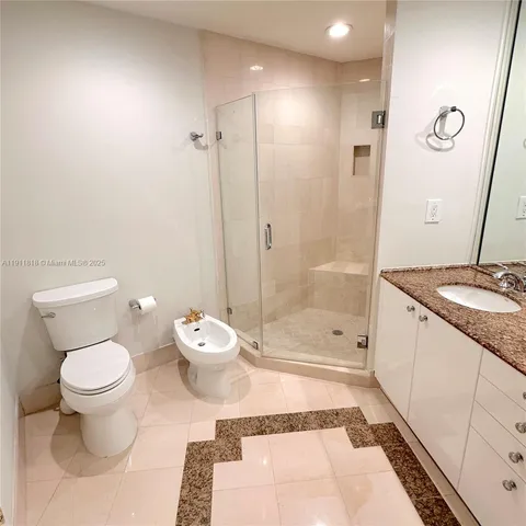 a bathroom with a granite countertop sink a toilet and shower
