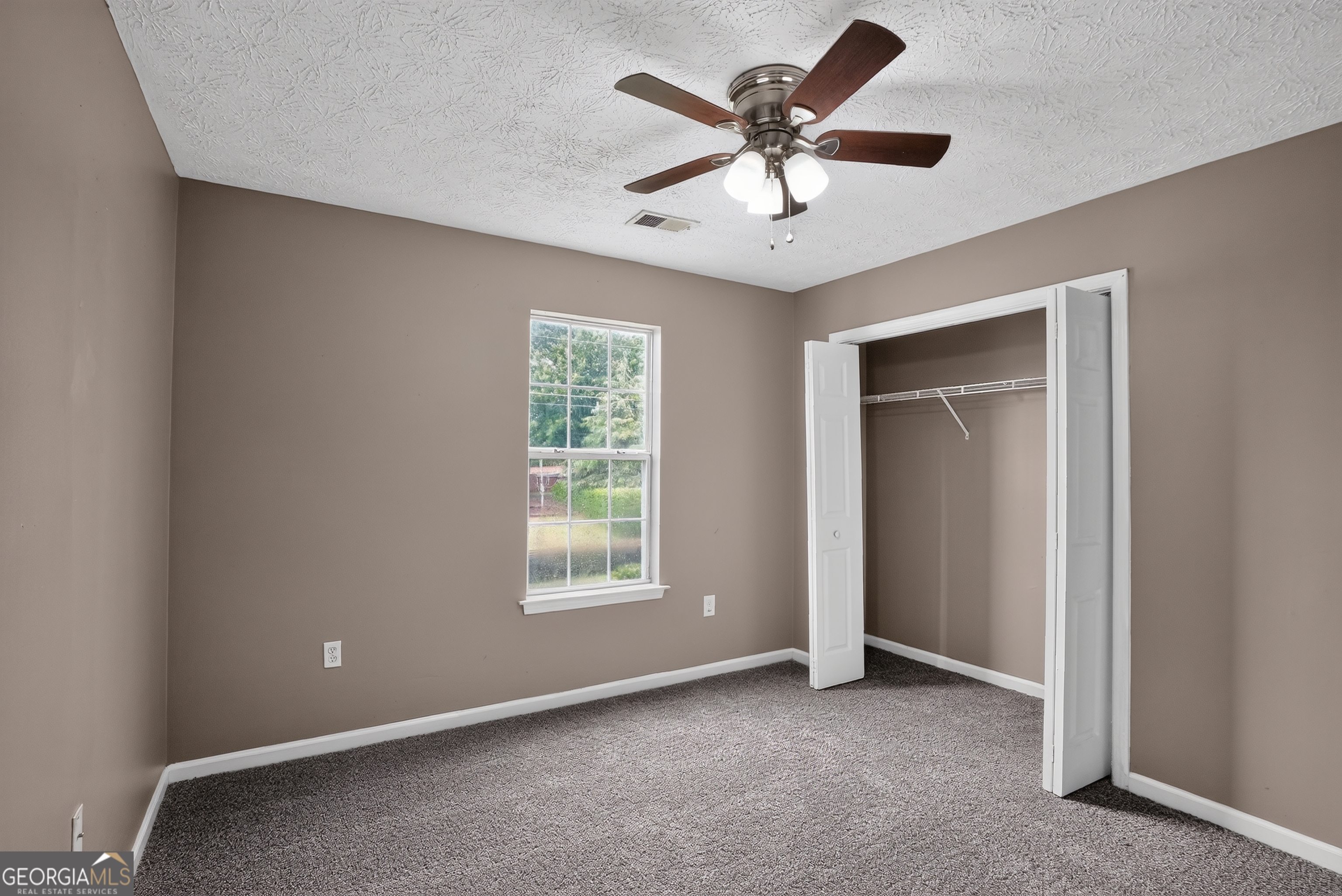 75 Linsley Way Covington, GA 30016 - Photo 44 of 48 an empty room with windows and fan