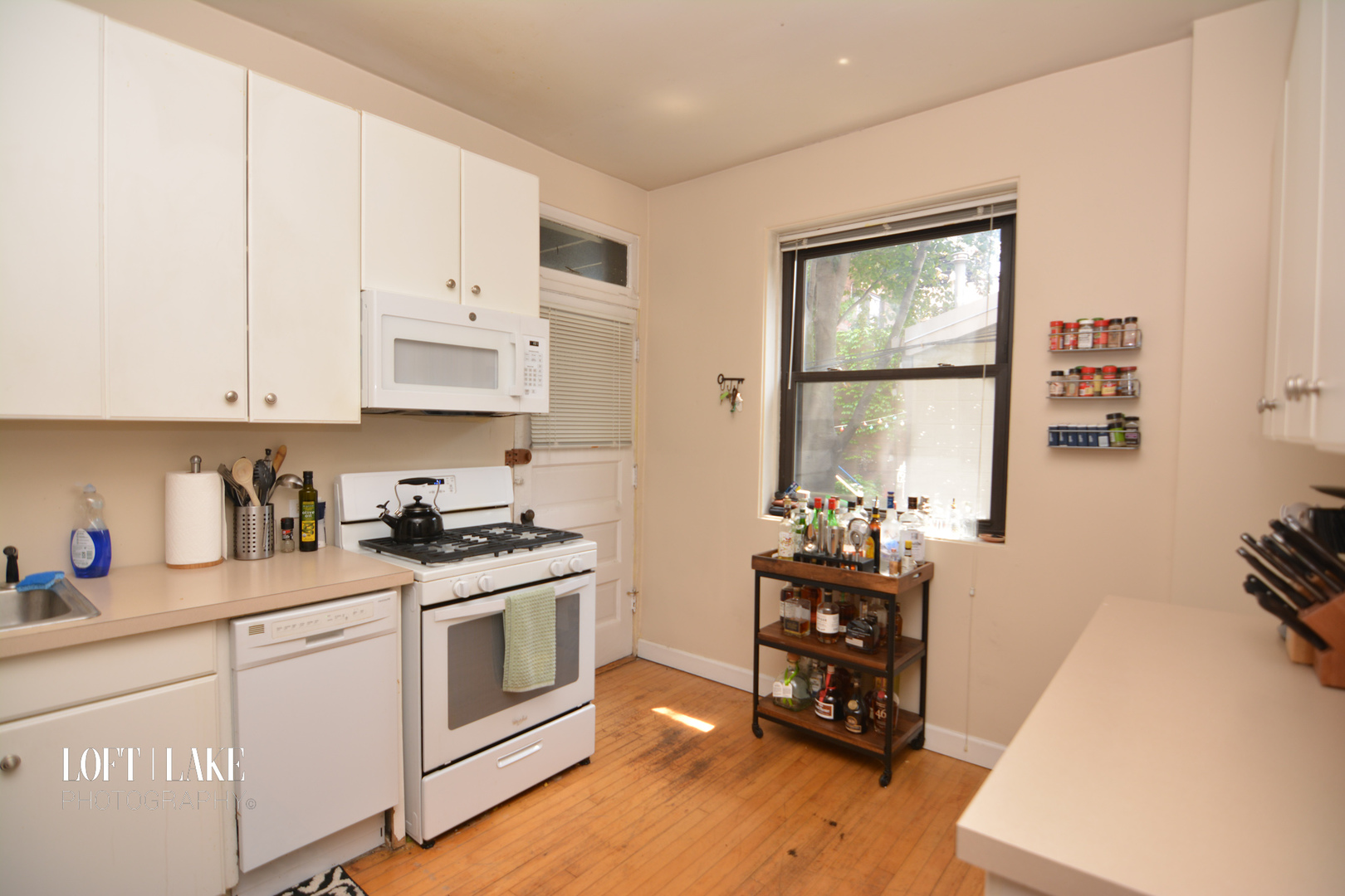 1611 West Grace Street, Unit 1 Chicago, IL 60613 - Photo 5 of 9 a kitchen with stainless steel appliances a white stove top oven and a wooden floor