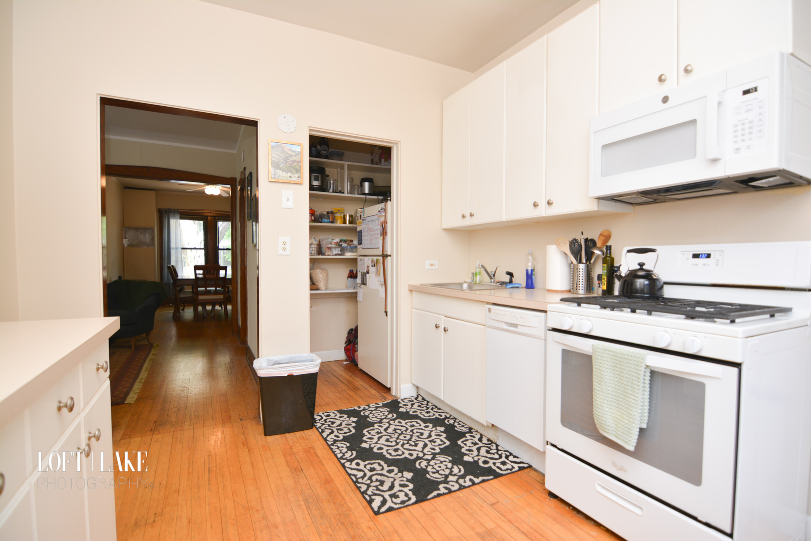 1611 West Grace Street, Unit 1 Chicago, IL 60613 - Photo 7 of 9 a kitchen with white cabinets and appliances