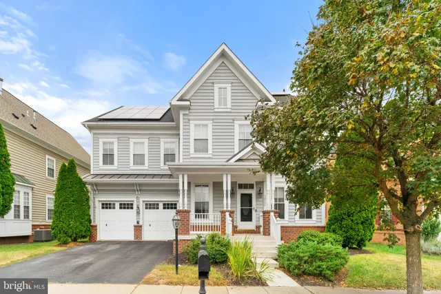 a front view of a house with a yard and potted plants