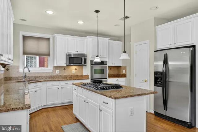a view of an empty room and chandelier fan