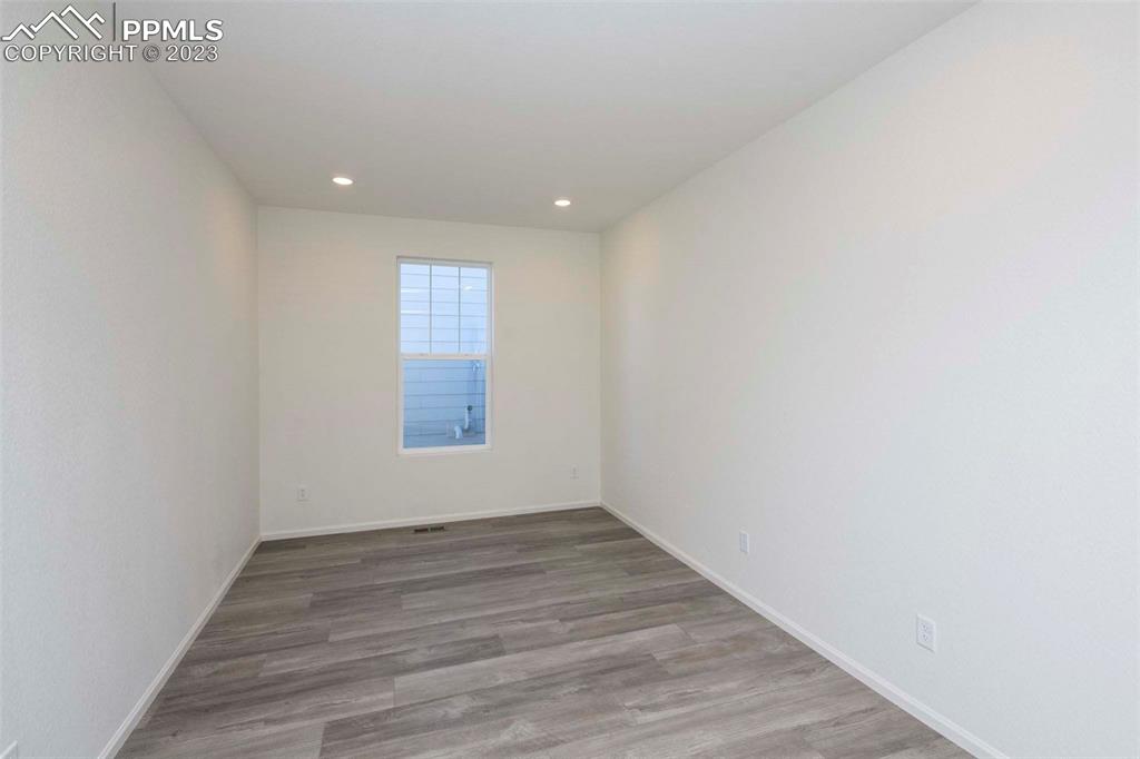 2045 Peachleaf Loop Castle Rock, CO 80108 - Photo 7 of 21 a view of an empty room with wooden floor and a window
