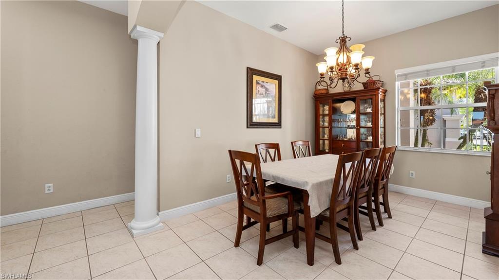 1730 Sarazen Place Naples, FL 34120 - Photo 14 of 50 a view of a dining room with furniture a chandelier and window