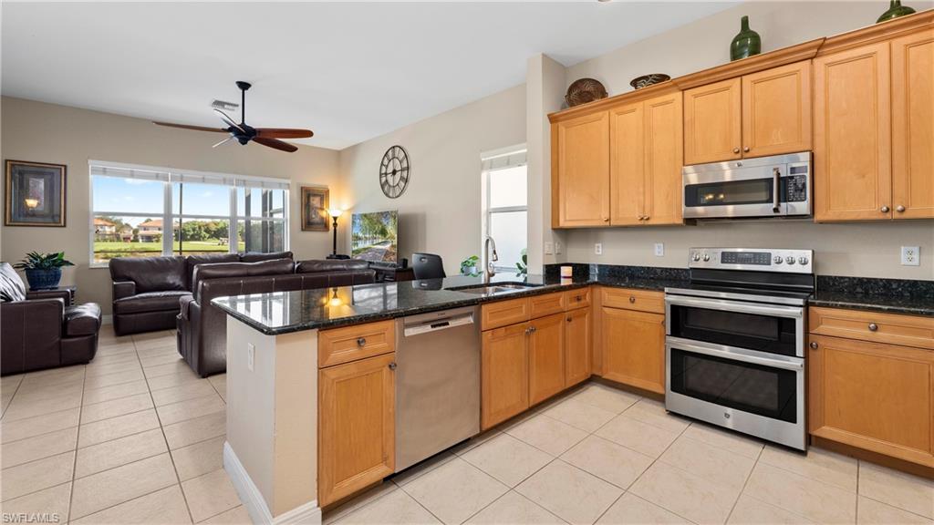 1730 Sarazen Place Naples, FL 34120 - Photo 16 of 50 a kitchen with stainless steel appliances granite countertop a stove a sink and a microwave