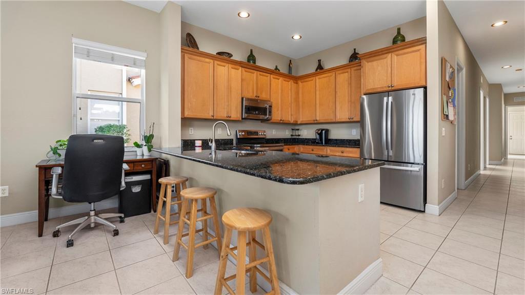 1730 Sarazen Place Naples, FL 34120 - Photo 18 of 50 a kitchen with a refrigerator a sink and cabinets