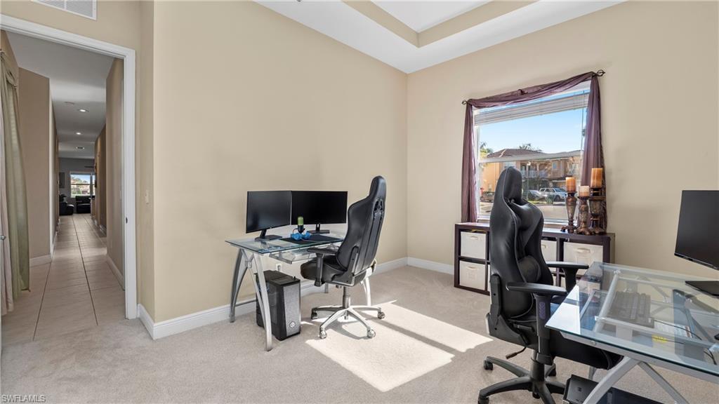 1730 Sarazen Place Naples, FL 34120 - Photo 26 of 50 a view of a workspace with furniture and a flat screen tv