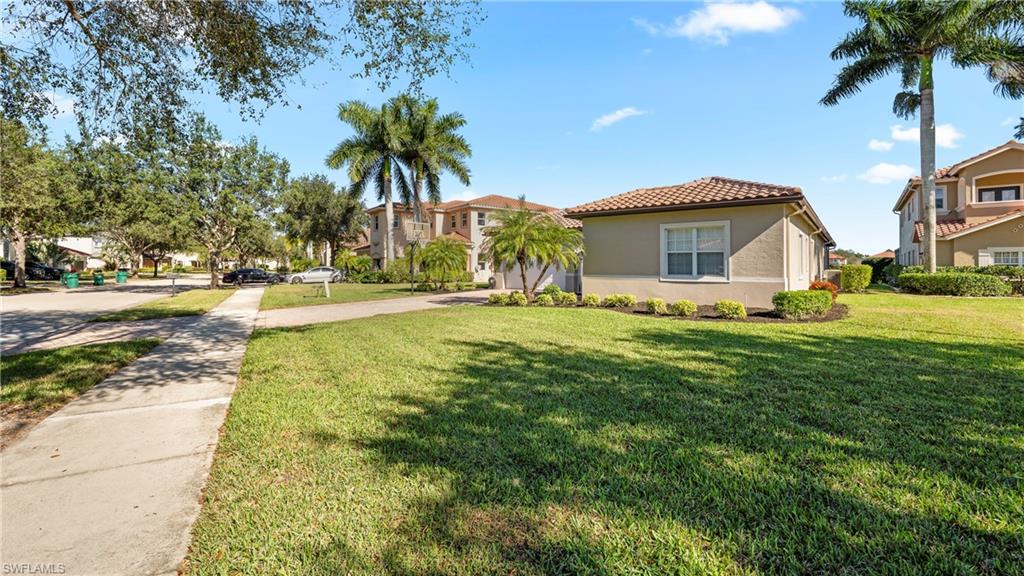 1730 Sarazen Place Naples, FL 34120 - Photo 40 of 50 a front view of a house with a yard and palm trees