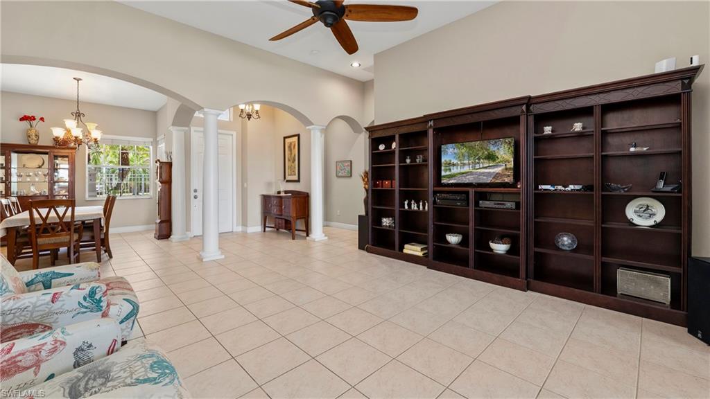 1730 Sarazen Place Naples, FL 34120 - Photo 9 of 50 a living room with furniture a lamp and a bookshelf