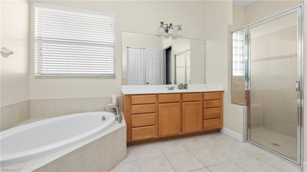 1730 Sarazen Place Naples, FL 34120 - Photo 10 of 50 a bathroom with a bathtub sink and mirror