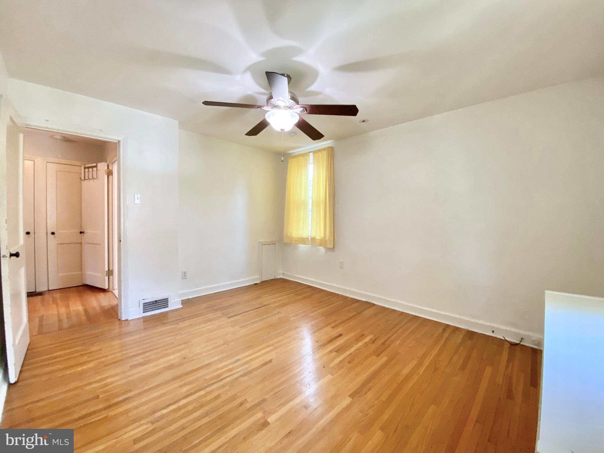 26 Hurst Road Wilmington, DE 19803 - Photo 21 of 74 an empty room with wooden floor chandelier fan and windows