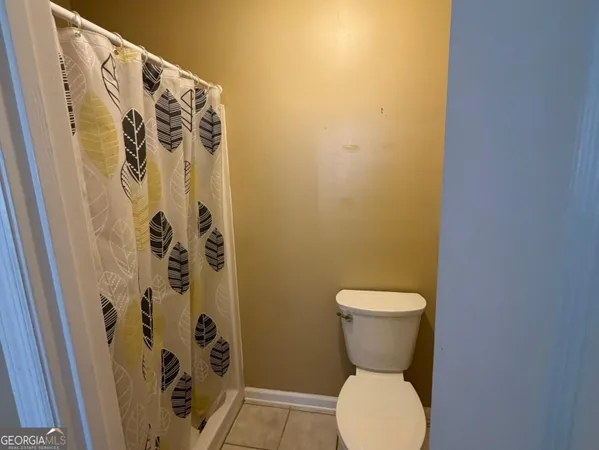 a bathroom with a toilet and a shower curtain